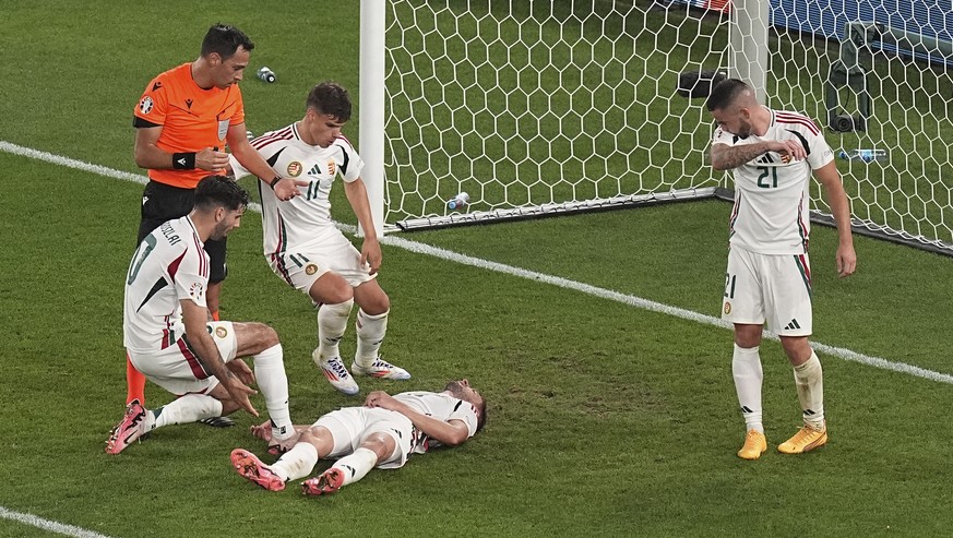 Hungary&#039;s Barnabas Varga lies on the pitch after an injury during a Group A match between Scotland and Hungary at the Euro 2024 soccer tournament in Stuttgart, Germany, Sunday, June 23, 2024. (AP ...
