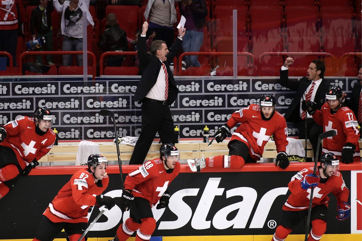 Sean Simpson, top left, head coach of Switzerland national ice hockey team, jubilates and Switzerland's players, from left, Martin Pluess, Simon Moser, Matthias Bieber, Thibaut Monnet, Luca Cunti ...