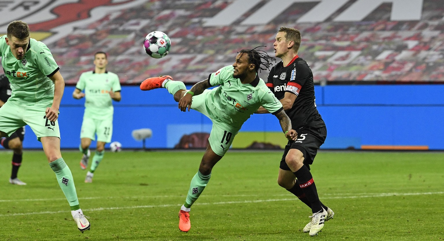 Moenchengladbach&#039;s Valentino Lazaro, center, scores an artistic third goal for his side beside Leverkusen&#039;s Sven Bender, right, during the German Bundesliga soccer match between Bayer Leverk ...