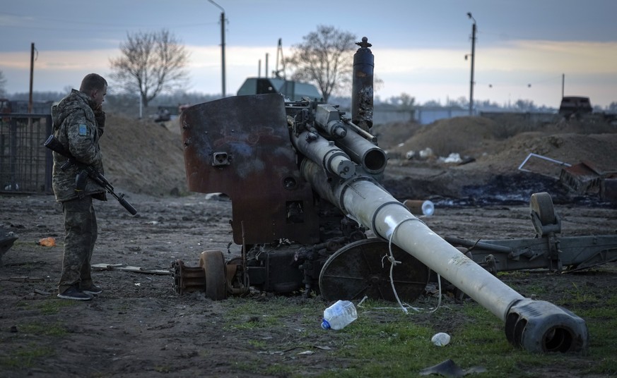 A Ukrainian soldier inspects a damaged Russian cannon in the recently retaken village Chornobaivka near Kherson, Ukraine, Tuesday, Nov. 15, 2022. (AP Photo/Efrem Lukatsky)