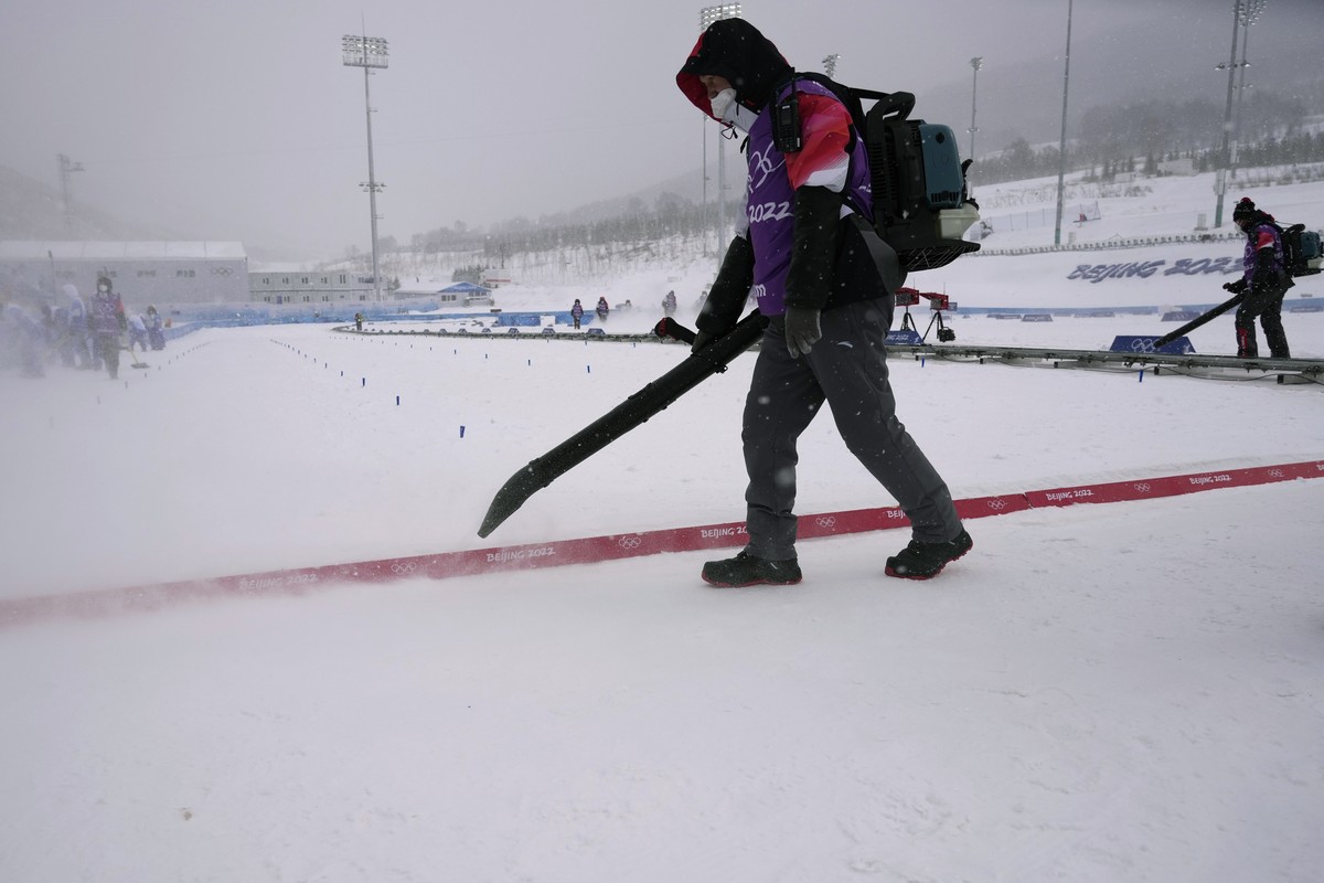 Workers clear the finish line of loose snow before the men's 4 x 10km relay cross-country skiing competition at the 2022 Winter Olympics, Sunday, Feb. 13, 2022, in Zhangjiakou, China. (AP Photo/A ...