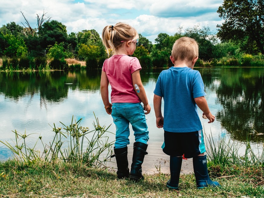 Kinder an Teich.