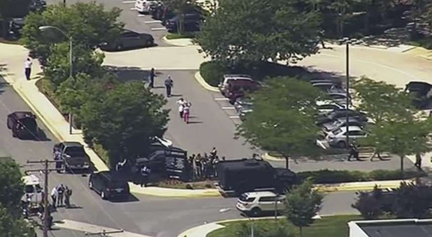 In this frame from video, people leave the Capital Gazette newspaper after multiple people have been shot on Thursday, June 28, 2018, in Annapolis, Md. (WJLA via AP)