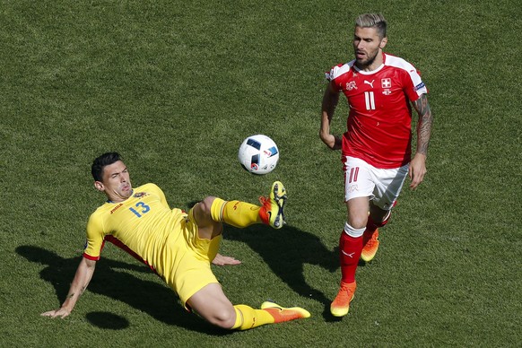 Romania&#039;s Claudiu Keseru, left, vies for the ball against Switzerland&#039;s Valon Behrami, right, during the Euro 2016 Group A soccer match between Romania and Switzerland at the Parc des Prince ...