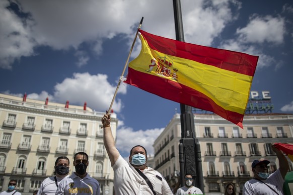 People wave Spanish flags as people hold a minute of silence for the victims of COVID-19 at Sol square in downtown Madrid, Spain, Wednesday, June 3, 2020. Spain&#039;s Health Ministry says it recorded ...