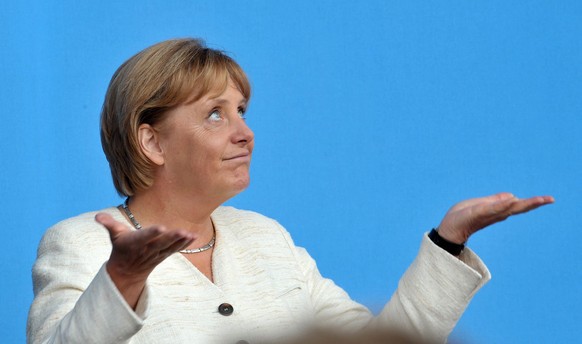 epa07207879 (FILE) - German Chancellor Angela Merkel and CDU (Germany&#039;s Christian Democrats) frontrunner in the upcoming Bundestag elections holds up her hands as it begins to rain during her spe ...