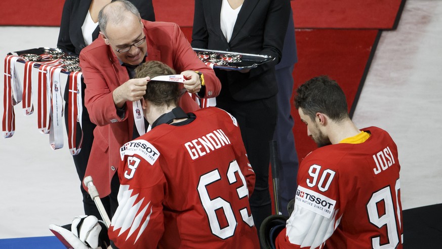 epa06753311 Swiss Defense and Sport Minister Guy Parmelin, left, gives the silver medal to Switzerland&#039;s goaltender Leonardo Genoni #63 past Switzerland&#039;s defender Roman Josi, after losing a ...