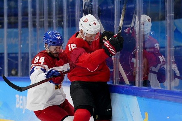 Czech Republic&#039;s Tomas Kundratek (84) and Switzerland&#039;s Gregory Hofmann (15) battle against the boards during a men&#039;s qualification round hockey game at the 2022 Winter Olympics, Tuesda ...