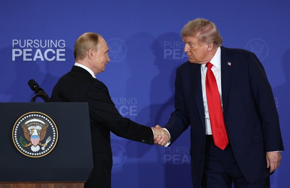 epa12303747 Russian President Vladimir Putin (L) and US President Donald Trump shake hands at the end of a joint news conference following their meeting at Joint Base Elmendorf-Richardson in Anchorage ...