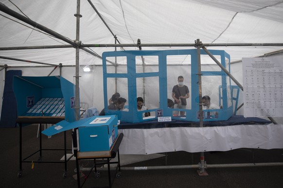 epa09091788 Employees of the Israeli elections commission works at a special polling station made for Israeli voters in quarantine, in Tel Aviv, Israel, 23 March 2021. Israelis went to the polls for a ...