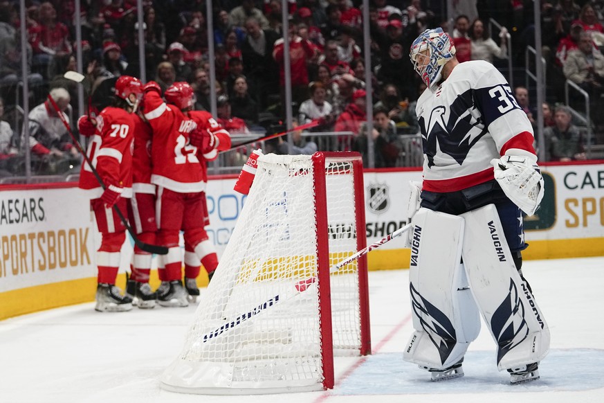 Washington Capitals goaltender Darcy Kuemper, right, looks on as Detroit Red Wings players celebrate a goal by Pius Suter during the third period of an NHL hockey game, Tuesday, Feb. 21, 2023, in Wash ...