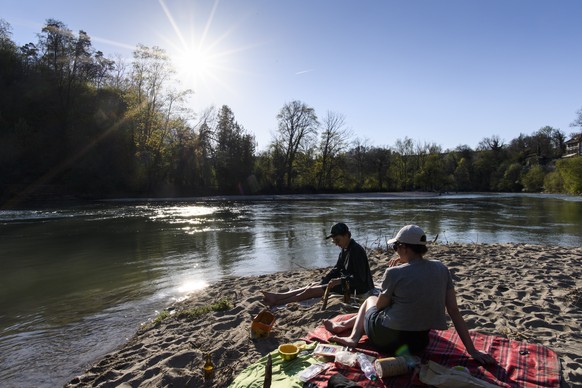 Katharina and Stefanie enjoy the sunny weather during a sunset at the river Aare, at Bremgarten bei Bern, Switzerland, on Thursday, April 19, 2018. (KEYSTONE/Anthony Anex)