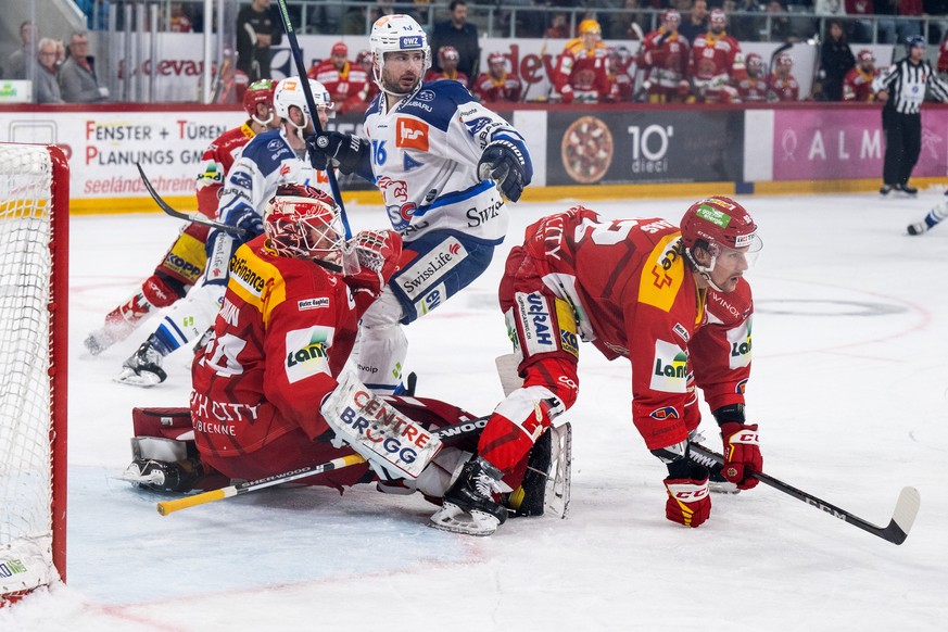 Biels Torhueter Dmitry Shikin, links, und Gaetan Haas, rechts, im Duell mit Zuerichs Marcus Krueger im sechsten Playoff Viertelfinal Eishockeyspiel der National League zwischen dem EHC Biel und den ZS ...