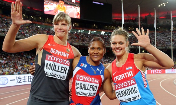 epa04897313 Cuba&#039;s Denia Caballero (C) celebrates after winning the gold medal in the women&#039;s Discus Throw final of the Beijing 2015 IAAF World Championships at the National Stadium, also kn ...