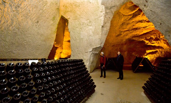 Visitors stand near bottles of Champagne in the caves of the Taittinger Champagne House in Reims, France, Wednesday, Oct. 14, 2014. For the citizens in Champagne during World War I, some weeks were so ...