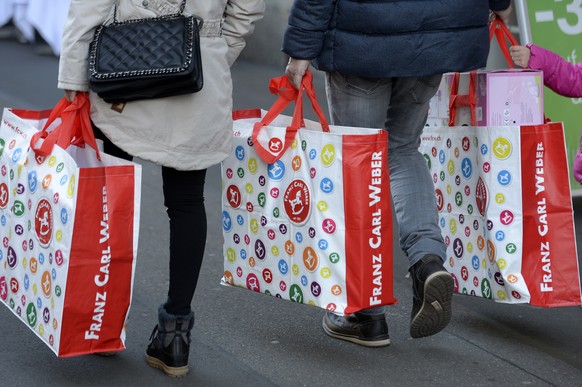 Personen tragen Franz Carl Weber Tragtaschen mit Geschenken beim Weihnachtseinkauf an der Zuercher Bahnhofstrasse am Samstag, 19. Dezember 2015. (KEYSTONE/Walter Bieri)