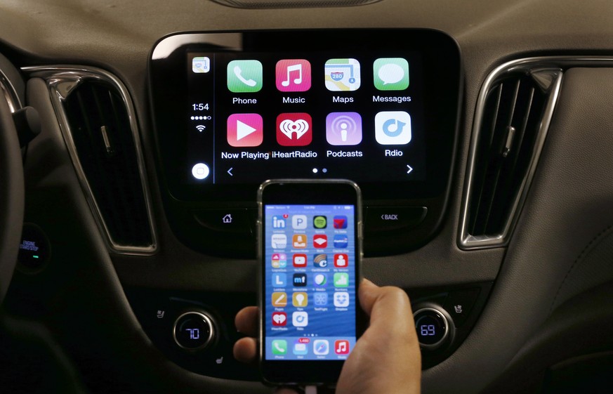 An iPhone is connected to a 2016 Chevrolet Malibu equipped with Apple CarPlay apps, displayed on the car&#039;s MyLink screen, top, during a demonstration in Detroit, Tuesday, May 26, 2015. Starting w ...