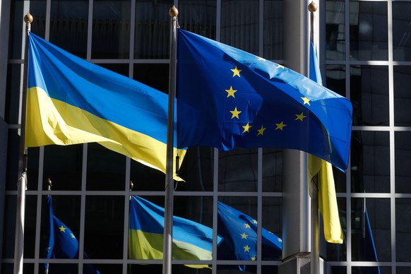 epaselect epa09791552 Ukrainian flags are hoisted along Flag of Europe to show solidarity with Ukraine over the Russian aggression, in front of the European Parliament in Brussels, Belgium, 28 Februar ...