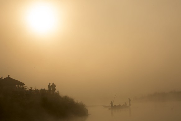 epa07256246 A Nepalese boat operator takes tourist out on the water during the first sunrise of 2019 at Chitwan National Park, Nepal, 01 January 2019. EPA/NARENDRA SHRESTHA