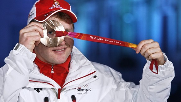 Swiss Ambrosi Hoffmann looks through the Bronze medal he won in today&#039;s Alpine Skiing Super-G race in the mixed zone of the medal ceremony in Turin, Italy, Saturday, February 18, 2006, during the ...