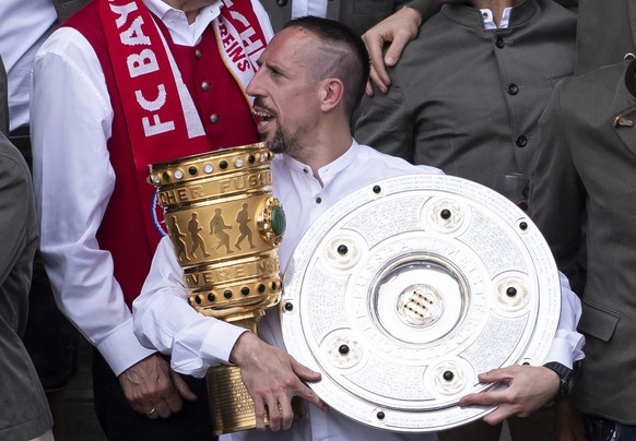 Soccer player Franck Ribery from FC Bayern Munich celebrates withy the trophies for the German league Bundesliga championship and the German soccer cup on the balcony of the city hall in Munich, May 2 ...