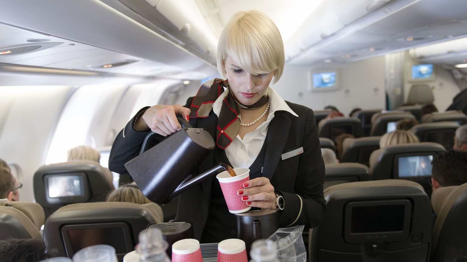 A flight attendant attends to the passengers of the Economy Class, pictured on April 29, 2013 in an aircraft of Swiss. Swiss, short for Swiss International Air Lines, flies from Zurich to Chicago and  ...