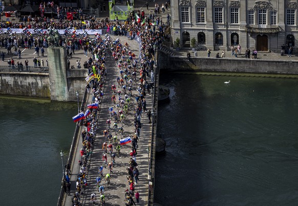 The pack of riders cross the Muenster bridge over the river Limmat during the Men Elite Road Race at the 2024 UCI Road and Para-cycling Road World Championships in Zurich, Switzerland on Sunday, Septe ...