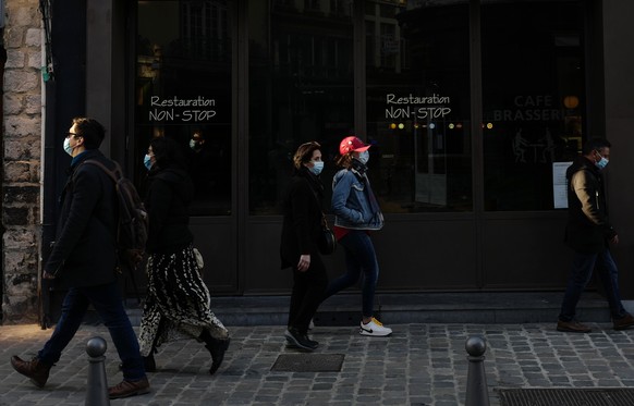 People walk past a closed restaurant in Lille, northern France, Saturday, March 20, 2021. The French government has backed off from ordering a tough lockdown for Paris and several other regions despite an increasingly alarming situation at hospitals with a rise in the number of COVID-19 patients. (AP Photo/Michel Spingler)