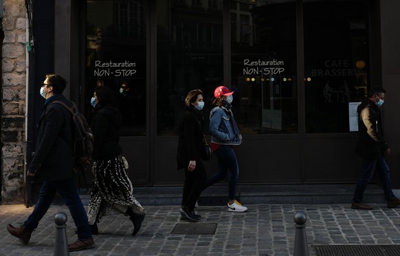 People walk past a closed restaurant in Lille, northern France, Saturday, March 20, 2021. The French government has backed off from ordering a tough lockdown for Paris and several other regions despit ...