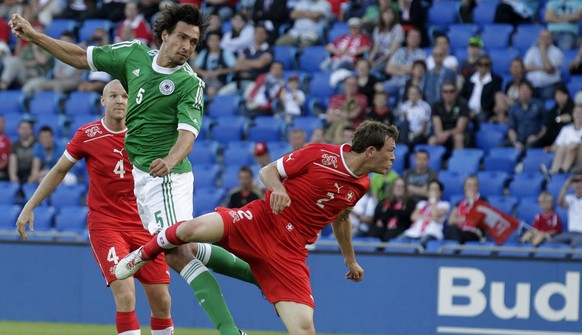 Germany&#039;s Mats Hummels, center, scores a goal between Swiss players Philippe Senderos, left, and Stephan Lichtsteiner, right, during an international friendly test game between the national socce ...