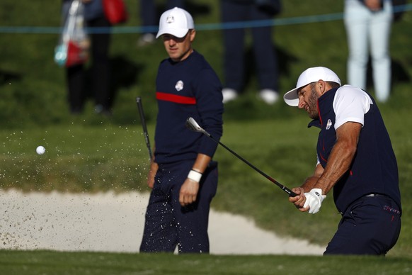 FILE - In this Sept. 25, 2018, file photo, the United States&#039; Jordan Spieth,left, watches as Dustin Johnson plays from a bunker on the third hole during practice at the Ryder Cup golf matches at  ...