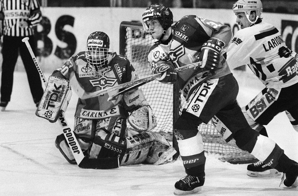 Der Klotener Anders Eldebrink, Mitte, klaert vor dem Tor seines Keepers Reto Pavoni und dem Luganesi Stuermer Igor Larionov, rechts, im Meisterschaftsspiel EHC Kloten gegen HC Lugano vom 13. MAerz 199 ...