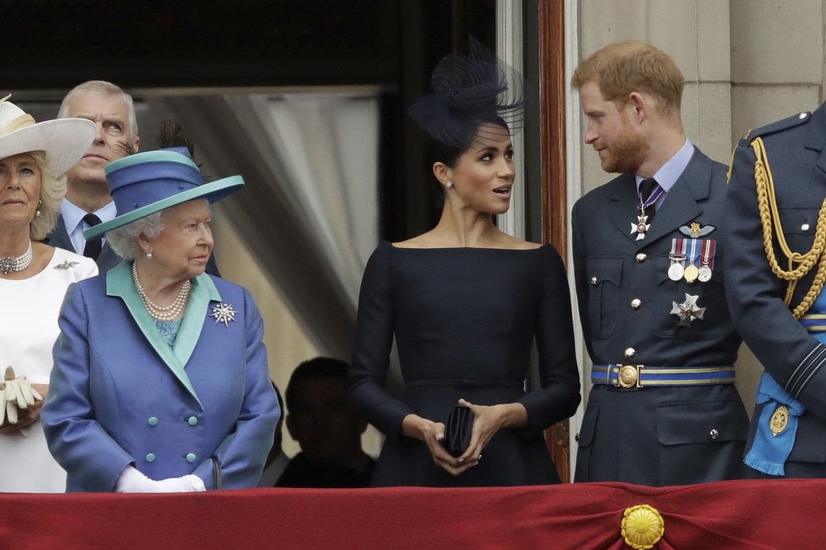 FILE - In this Tuesday, July 10, 2018 file photo Britain's Queen Elizabeth II, Meghan the Duchess of Sussex and Prince Harry stand on a balcony to watch a flypast of Royal Air Force aircraft pass ...