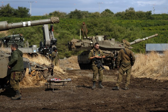 epa10305559 Israeli soldiers stand next to tanks and APCs ahead of a large Armored Corps exercise that will take place in the Israeli-annexed Golan Heights, near the border with Syria, 14 November 202 ...