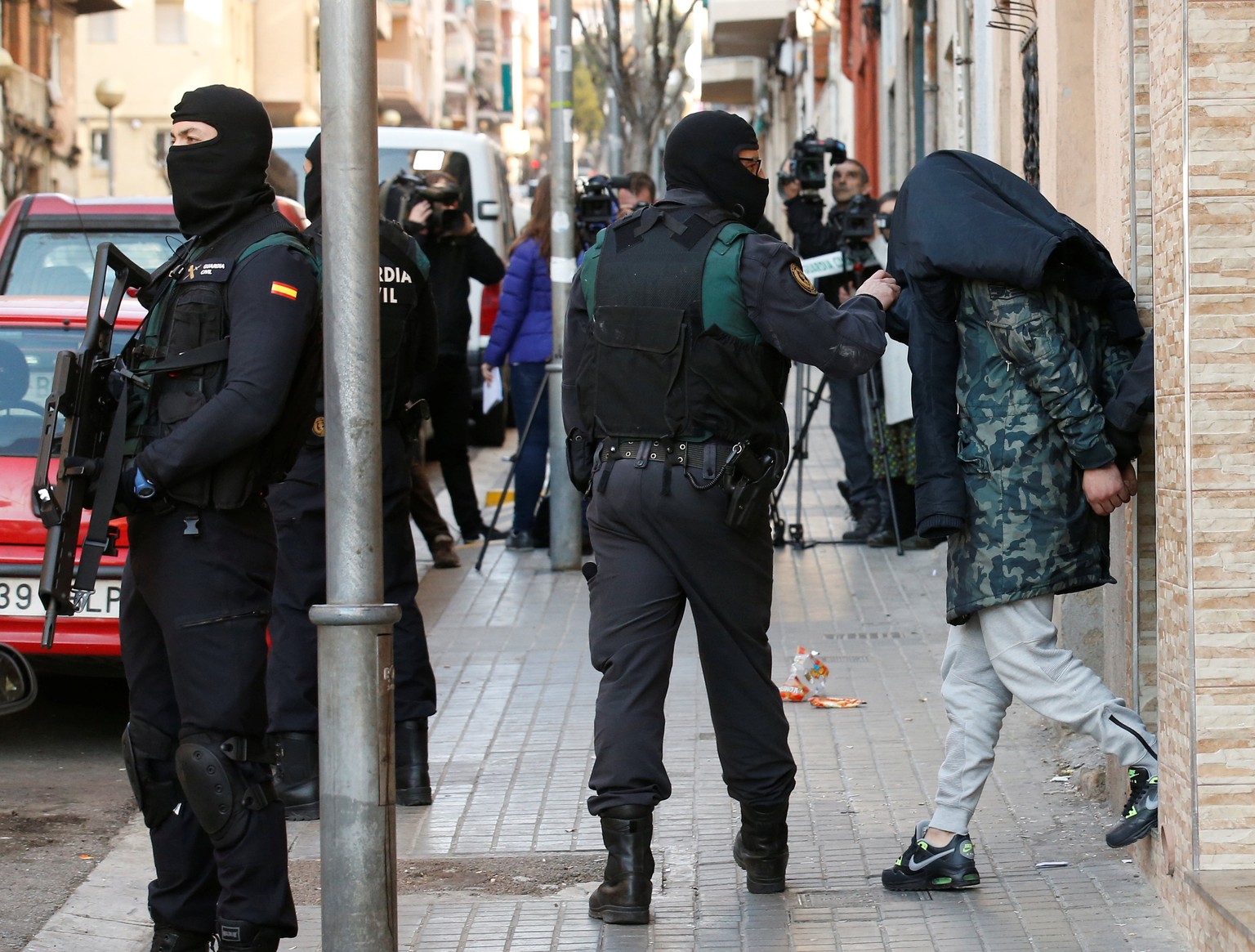 Spanish civil guards escort a detained suspect, accused of recruiting and training potential combatants for the Islamic State, in Badalona, northeastern Spain, February 7, 2017. REUTERS/Albert Gea TPX ...