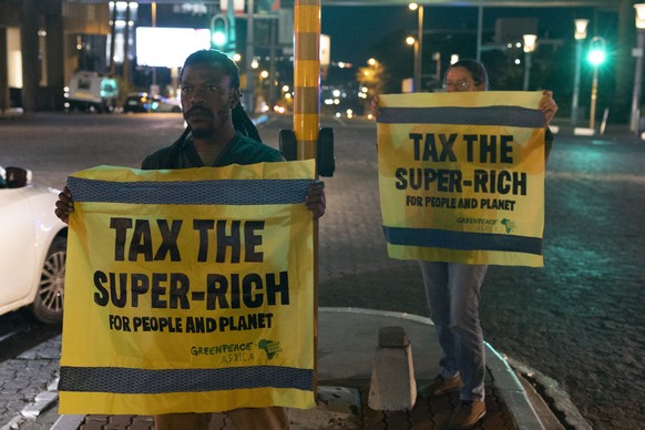 epa12536521 Protestors from Greenpeace stand in Sandton City during a anti G20 protest in Johannesburg, 19 November 2025. The two-day summit is scheduled for 22?23 November 2025, with 42 countries con ...