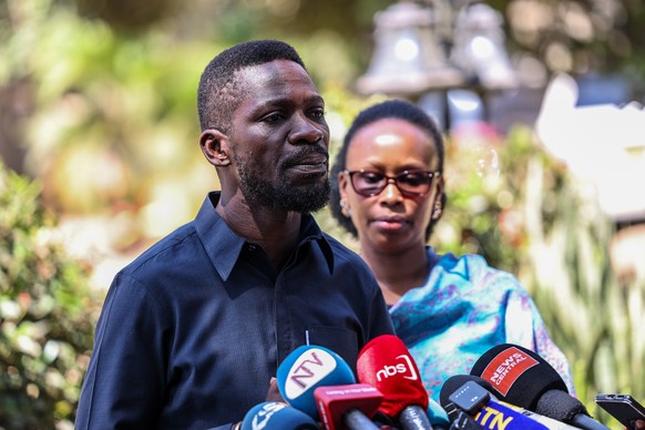 epa12651159 Uganda's opposition leader Robert Kyagulanyi, popularly known as Bobi Wine (L), and his wife Barbra Itungo (R), prepare to vote during the presidential elections at the Kamwokya in Ka ...