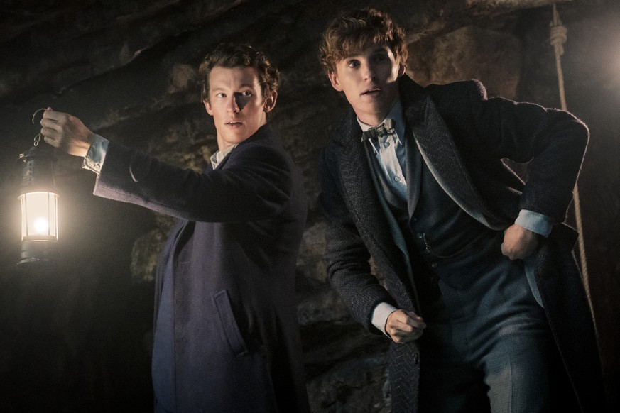 This image released by Warner Bros. Pictures shows Callum Turner, left, and Eddie Redmayne in a scene from &quot;Fantastic Beasts: The Secrets of Dumbledore.&quot; (Warner Bros. Pictures via AP)