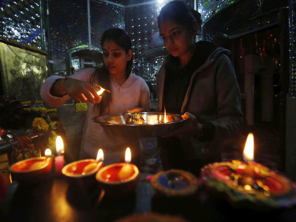 epa10263195 Hindu women pray inside a temple on Diwali, one of the most important Hindu religious festivals, in Srinagar, the summer capital of Indian Kashmir, 24 October 2022. Diwali, the Hindu festi ...