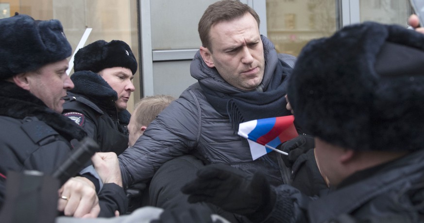 Russian opposition leader Alexei Navalny, centre, is detained by police officers in Moscow, Russia, Sunday, Jan. 28, 2018. Opposition politician Alexey Navalny calls for nationwide protests following  ...