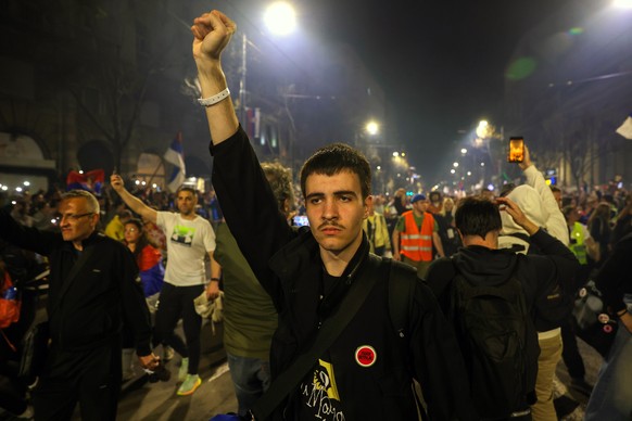 epaselect epa11964851 A university student holds his fist high while marching into Belgrade, Serbia, 14 March 2025. University students staged a protest, demanding accountability after fifteen people  ...