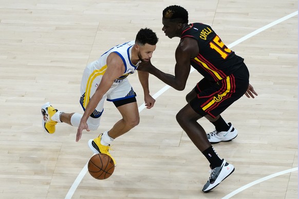 Golden State Warriors guard Stephen Curry (30) drives against Atlanta Hawks center Clint Capela (15) during the first half of an NBA basketball game Sunday, April 4, 2021, in Atlanta. (AP Photo/John B ...