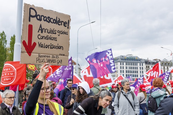 Des manifestants avec des pancartes et des drapeaux defilent dans les rues de Geneve, lors du defile du 1er mai - Fete du Travail, ce lundi 1 mai 2023 a Geneve. A Geneve, quelques milliers de personne ...