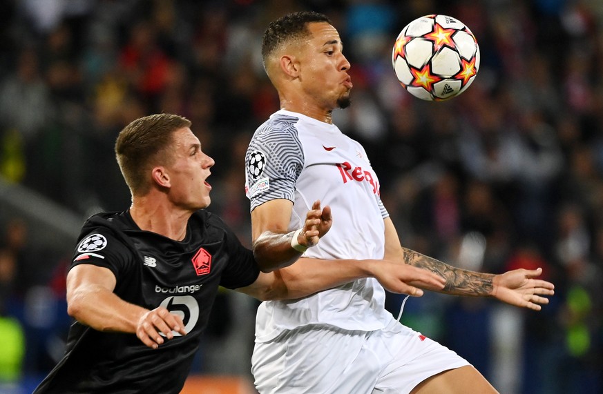 epa09496213 Noah Okafor (R) of Salzburg in action against Sven Botman of Lille during the UEFA Champions League group G soccer match between FC Salzburg and Lille OSC in Salzburg, Austria, 29 Septembe ...