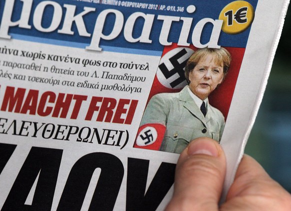 epa03097513 The front page of Greek right-wing daily &#039;Democracy&#039; shows a photoshop photo of German Chancellor Angela Merkel with a Nazi arm band, in Athens, Greece, on 09 February 2012. Anti ...