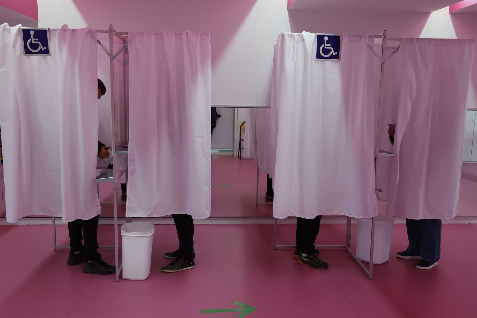 People stand at the voting booth in the first round of the French presidential election, in Strasbourg, eastern France Sunday, April 10, 2022. The polls opened at 8am in France for the first round of  ...