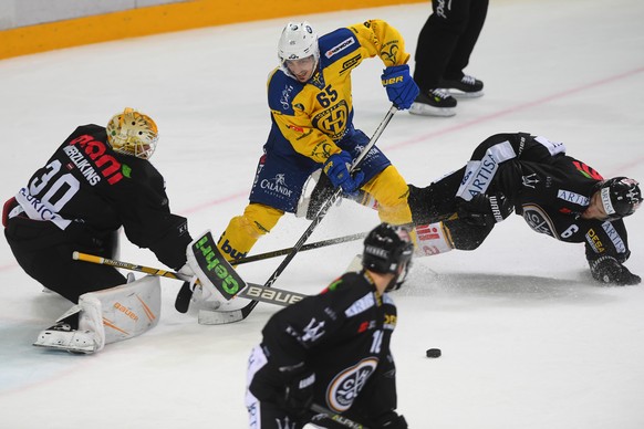 Lugano&#039;s goalkeeper Elvis Merzlikins, Davos&#039; player Marc Wieser, Lugano&#039;s player Massimo Ronchetti, from left, during the preliminary round game of National League Swiss Championship 20 ...