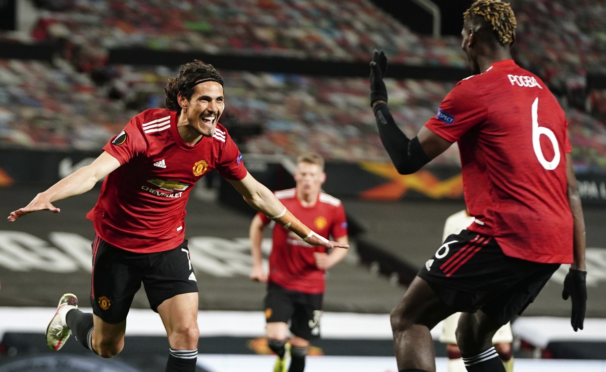Manchester United's Edinson Cavani, left, celebrates after scoring his side's third goal during the Europa League semi final, first leg soccer match between Manchester United and Roma at Old ...