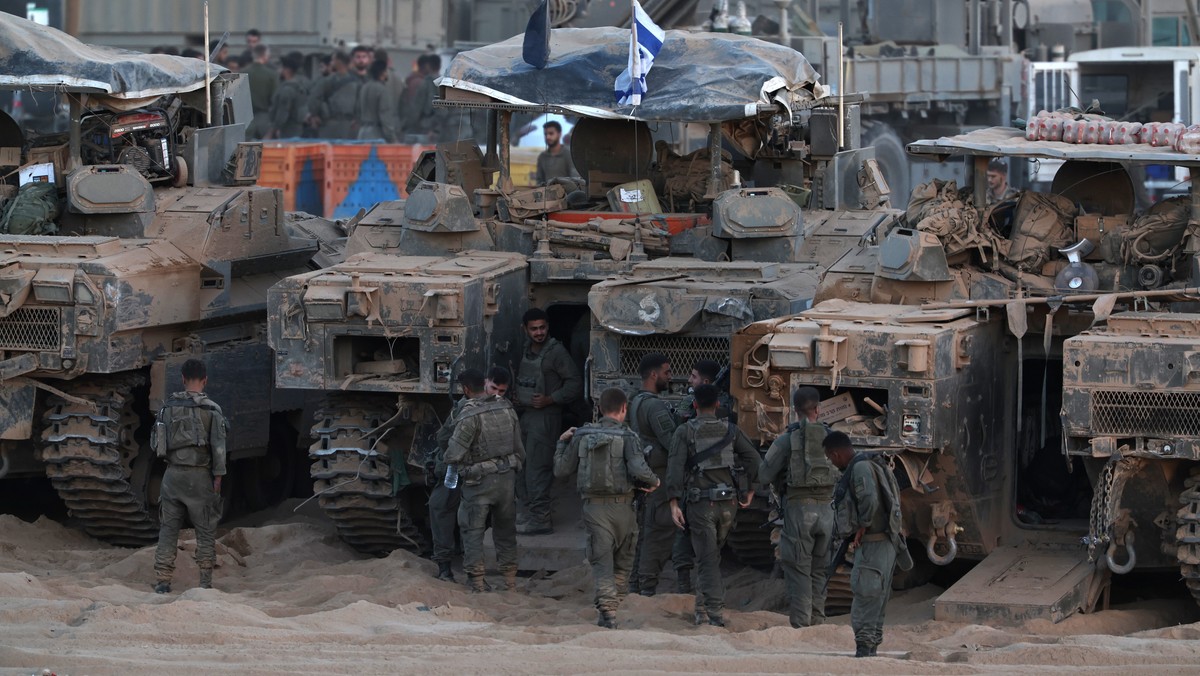 epa12444025 Israeli soldier next to their tanks at a gathering site after withdrawing from the Gaza Strip following the Israel-Hamas agreement on the first phase of the Gaza peace plan, near the Israe ...