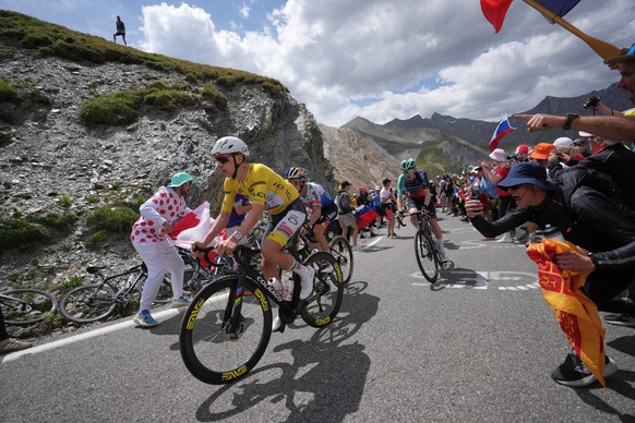 Slovenia's Tadej Pogacar, wearing the overall leader's yellow jersey, climbs the Galibier pass ahead of Belgium's Remco Evenepoel, center, and France's Paul Seixas, right, during t ...